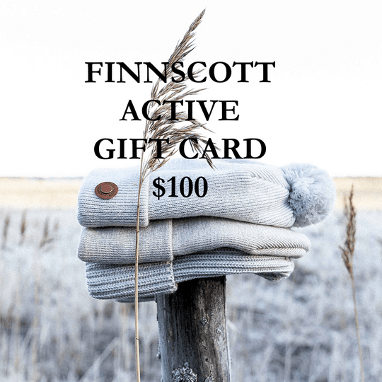 Stack of grey beanies on a wooden post with 'FINNSSCOTT ACTIVE GIFT CARD $100' text against a blurred natural background.