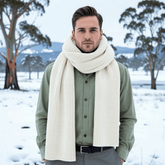 Man wearing a large white scarf in a snowy landscape